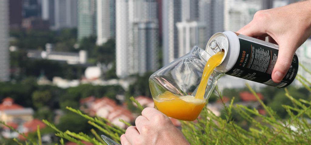 A can of mango sour craft beer being poured into a beer glass for delivery in singapore